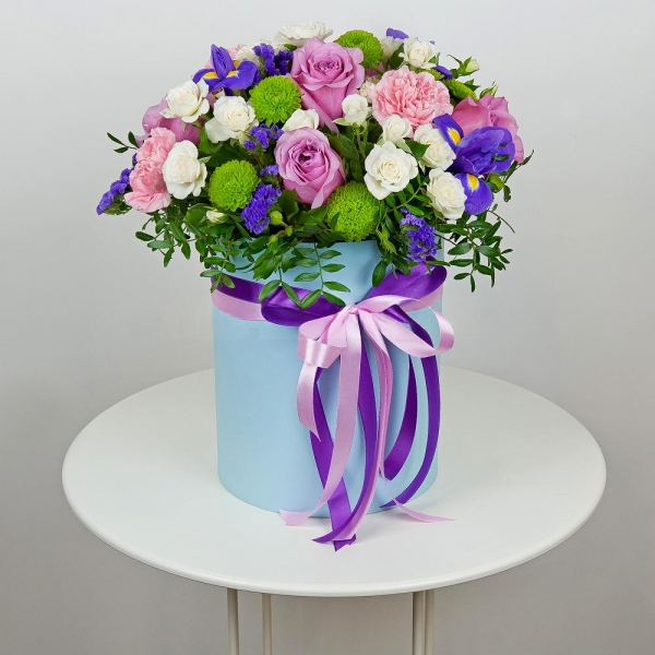 Deep Purple rose - 7, Spray rose: white, cream, light pink 50 cm - 11, Pink carnation - 5, Irises - 5, Athos pom Feeling Green - 4, Round flower box medium, Oasis, Film, Pistachio, Blue Statice, Ribbon