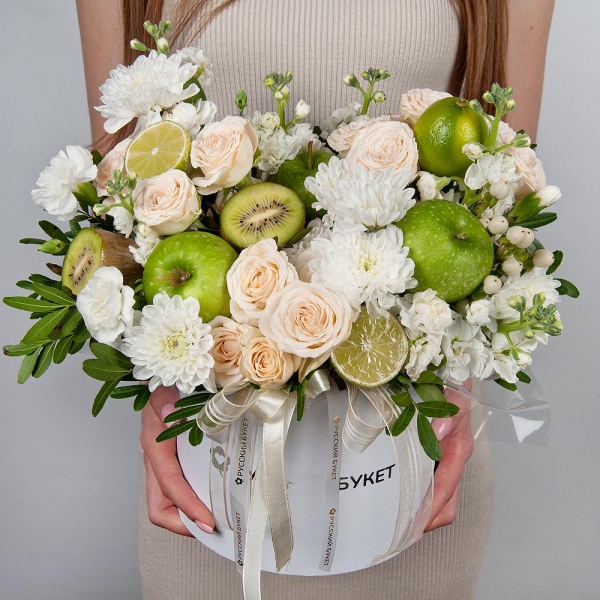 Baltica White Spray Chrysanthemum - 5, Peony sprayrose - 3, White Matthiola - 2, White spray carnation - 5, Round flower box medium, Oasis, Pistachio, Hypericum, Apple, 1 pc., Kiwi, Lemon, 1 pc., Wrapping Paper