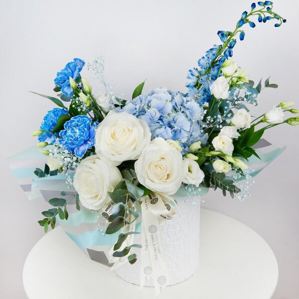 Blue/purple hydrangea - 1, Blue carnation - 3, White rose 50 cm - 3, lisianthus - 3, Colored gypsophila - 1, Round flower box small , Oasis, Wrapping Paper, Ruscus, Eucalyptus Cinerea, Blue Delphinium