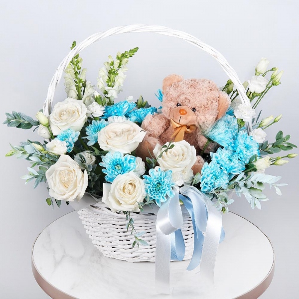 White Matthiola - 2, White rose 50 cm - 5, Chrysanthemum spray Baltica painted blue - 2, White spray carnation - 2, lisianthus - 2, Medium Basket, Oasis, Pistachio, Teddy bear 20 cm, Ribbon