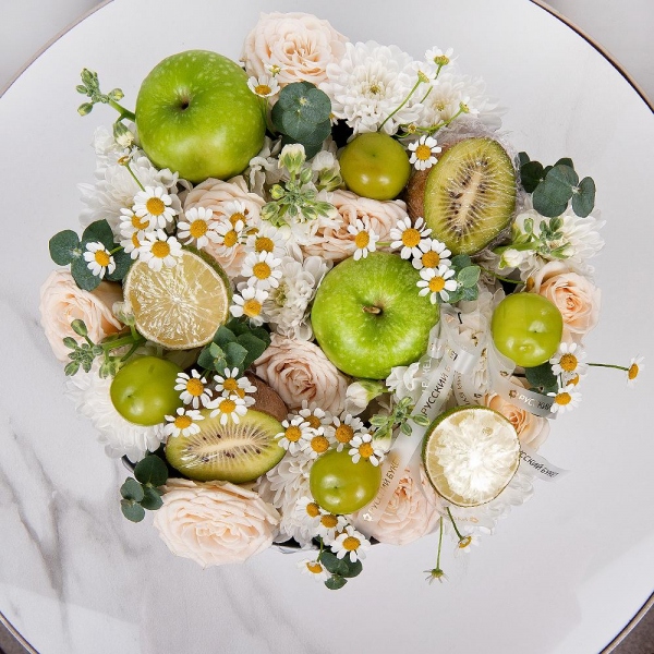 Baltica White Spray Chrysanthemum - 1, White Matthiola - 4, Peony sprayrose - 3, Chamomile - 3, Circular arrangement box, Oasis, Eucalyptus, Kiwi, Apple, 1 pc., Lemon, 1 pc., Grapes, Wooden skewer, Grapes, Ribbon