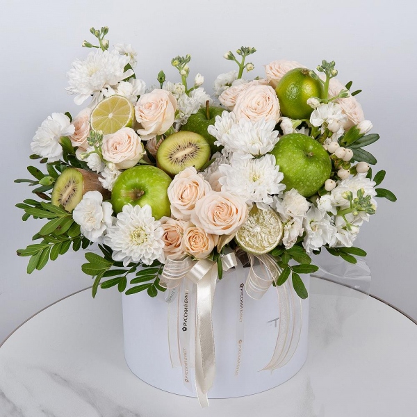 Baltica White Spray Chrysanthemum - 5, Peony sprayrose - 3, White Matthiola - 2, White spray carnation - 5, Round flower box medium, Oasis, Pistachio, Hypericum, Apple, 1 pc., Kiwi, Lemon, 1 pc., Wrapping Paper