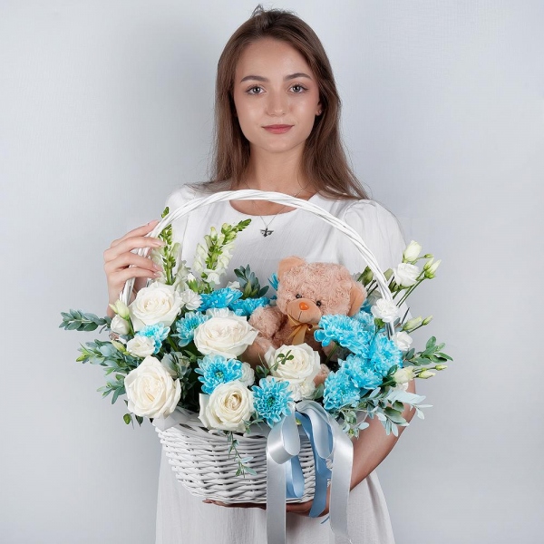 White Matthiola - 2, White rose 50 cm - 5, Chrysanthemum spray Baltica painted blue - 2, White spray carnation - 2, lisianthus - 2, Medium Basket, Oasis, Pistachio, Teddy bear 20 cm, Ribbon