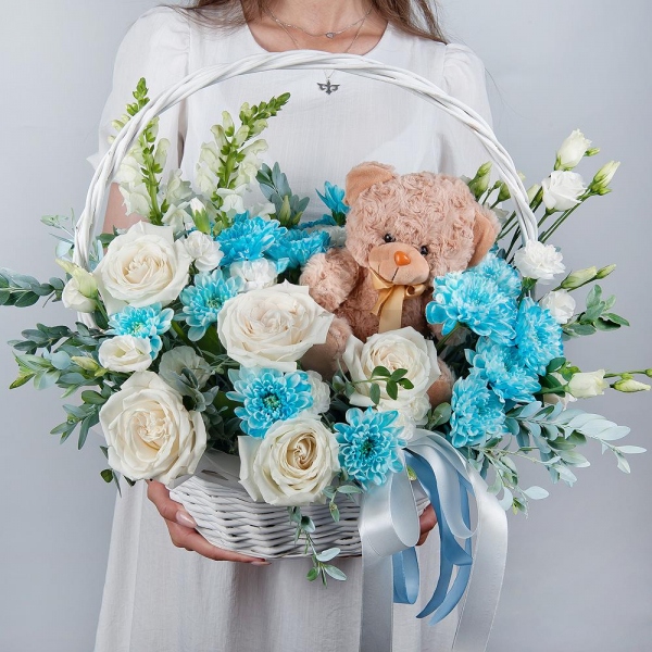 White Matthiola - 2, White rose 50 cm - 5, Chrysanthemum spray Baltica painted blue - 2, White spray carnation - 2, lisianthus - 2, Medium Basket, Oasis, Pistachio, Teddy bear 20 cm, Ribbon