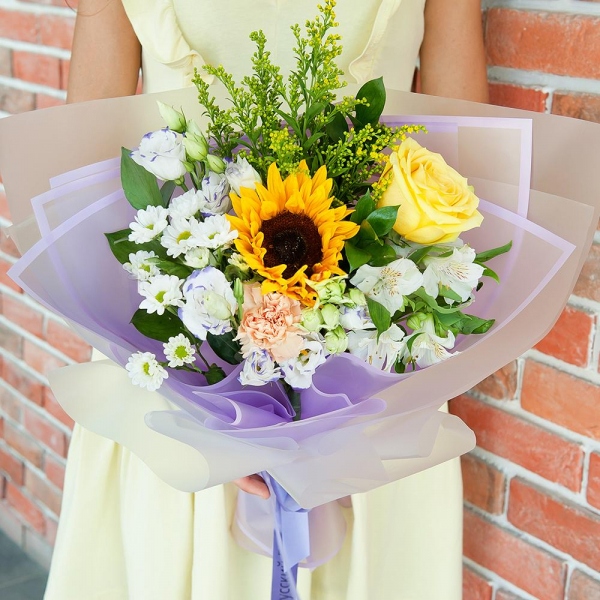 Sunflower - 1, Yellow rose 50 cm - 1, Carnation white, cream - 1, Santini White Spray Chrysanthemum - 1, Alstromeria white, soft pink - 1, lisianthus - 2, Solidago (1 pc.), Ruscus, Ribbon, Wrapping Paper