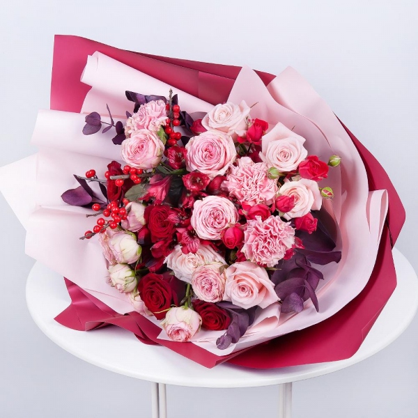Spray rose: red 50 cm - 4, Peony sprayrose - 2, Pink carnation - 4, Alstromeria Red, Bright Pink - 2, Red rose 50 cm - 5, Pink rose 50 cm - 5, Ilex, Eucalyptus Cinerea, Wrapping Paper, Ribbon