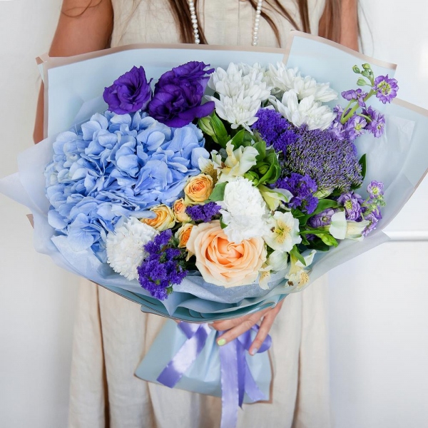 Matthiola Lilac - 2, Rose Cream 50 cm - 1, Carnation white, cream - 3, Spray rose: white, cream, light pink 50 cm - 2, Blue/purple hydrangea - 1, Alstromeria white, soft pink - 2, Baltica White Spray Chrysanthemum - 2, Purple Lisianthus (Eustoma) - 1, Trachelium, Blue Statice, Wrapping Paper