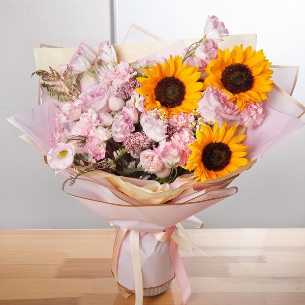 Sunflower - 3, Pink carnation - 9, Pink Lisianthus (Eustoma) - 3, Pink rose 50 cm - 7, Chamomile - 3, Peony sprayrose - 3, Ozotamnus, Fern (1 pc.), Wrapping Paper