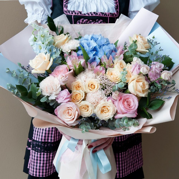 Blue/purple hydrangea - 1, Pink rose 50 cm - 5, Spray rose: white, cream, light pink 50 cm - 4, Rose Cream 50 cm - 6, Alstromeria white, soft pink - 5, Carnation white, cream - 9, Pink Lisianthus (Eustoma) - 3, Ozotamnus, Limonium (1 pc.), Blue Delphinium, Ruscus, Eucalyptus, Wrapping Paper