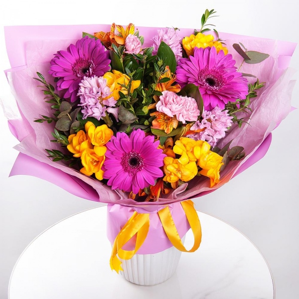 Purple gerbera - 5, Pink Hyacinth - 4, Alstromeria Yellow, Orange - 5, Pink spray carnation - 5, Freesia - 4, Pistachio, Eucalyptus, Wrapping Paper